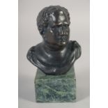 A SMALL BRONZE BUST OF A ROMAN on a marble base. 3.75ins high.