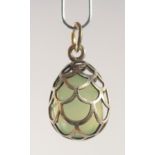 A SILVER AND JADE EGG SHAPED PENDANT, of cage design. 2cm high.