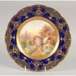 A ROYAL WORCESTER SUPERB PLATE painted with an English cottage having a floriferous garden ,the