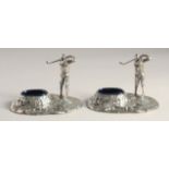 A PAIR OF SILVER PLATED GOLFER SALTS with blue liners.