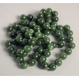 A GOOD LONG JADE BEAD NECKLACE. 32ins long.