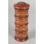 A WOODEN SPICE TOWER: CLOVES, GINGER, MACE NUTMEG.