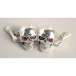 A PAIR OF SILVER SKULL CUFF LINKS.