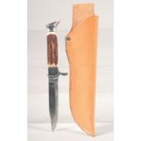 A KNIFE, with thumb guard and antler handle, in a leather sheath, 8" long.