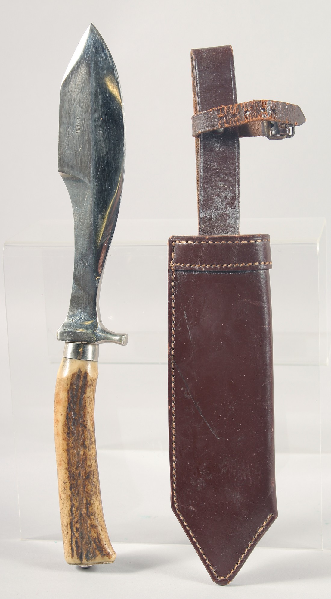 A HENEJU KNIFE, with an antler handle, 13" long, with a leather sheath.