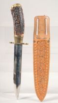 A KNIFE, with brass mounts and antler handle, in a sheath with oak leaves, 10" long.