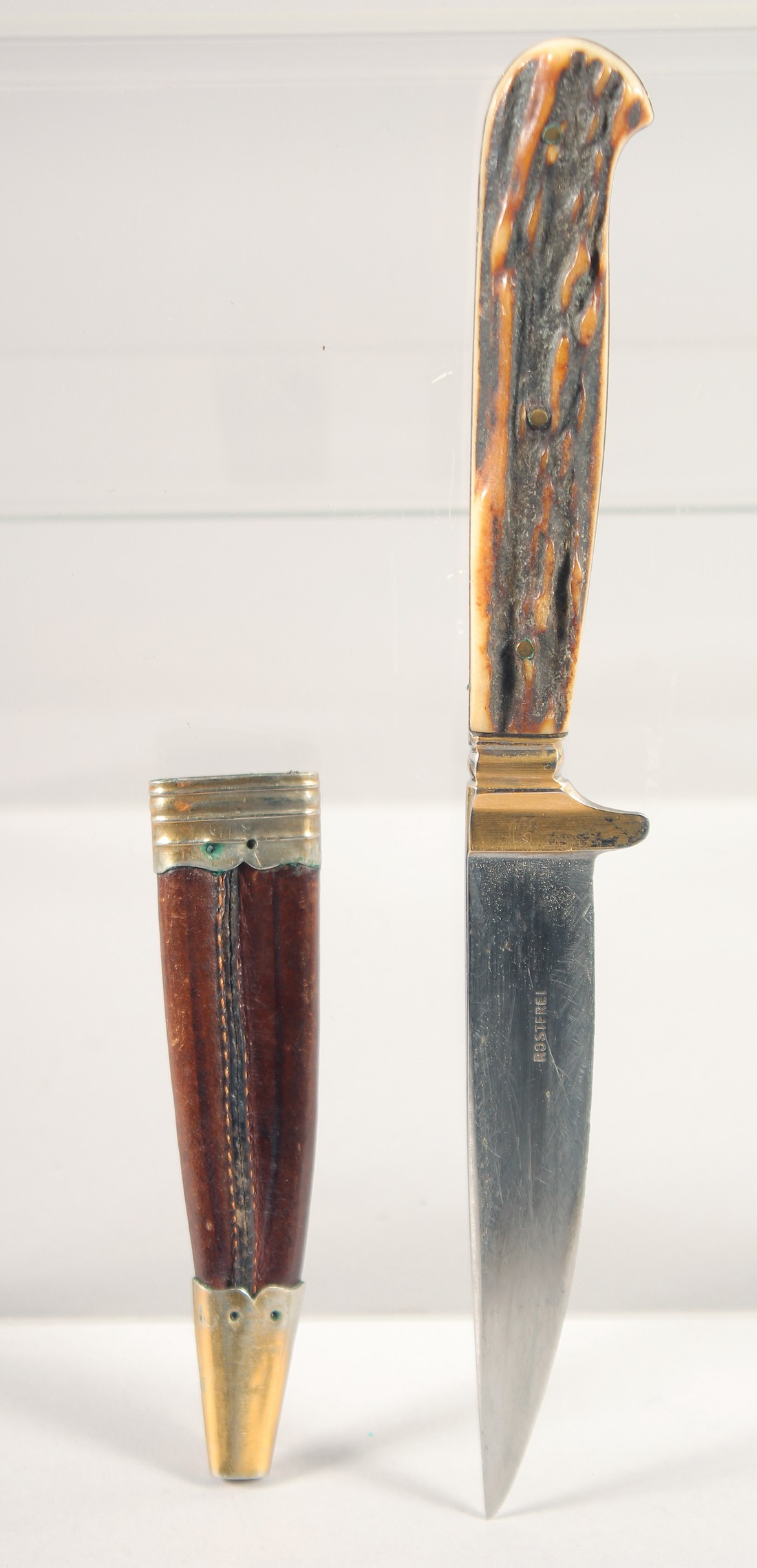 A ROSTFREI KNIFE, with antler handle, in a sheath, 7.5" long.