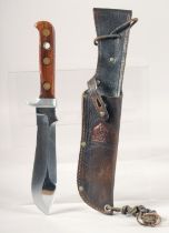 AN AUTO MESSER PUMA KNIFE, with wooden handle, 10" long, in a leather sheath.