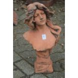 A terracotta coloured classical bust of a young woman.