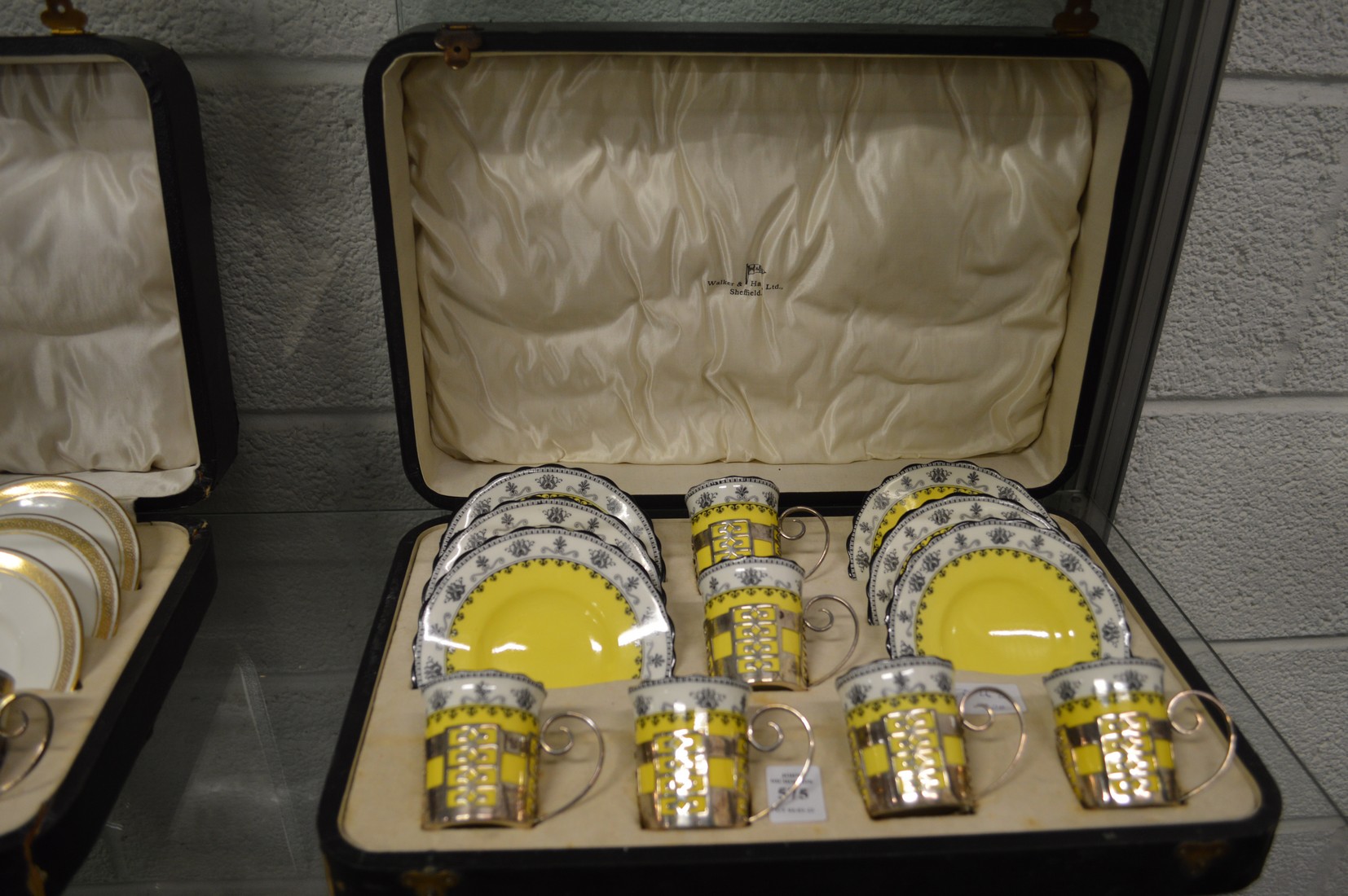 A cased set of six Aynsley porcelain coffee cans and saucers with pierced silver holders.