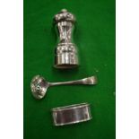 A silver pepper grinder and two other items.