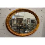Decorative gilt framed oval wall mirror.
