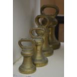 A graduated set of four brass bell weights.