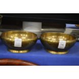 A pair of heavy brass bowls.
