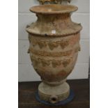 A large salt glazed vase shaped urn with grape and vine decoration.