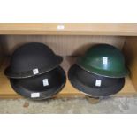 Four old WWII tin helmets.