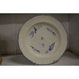 A Chantilly creamware plate with basket weave border painted with blue flowers.
