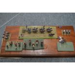Large perspex case containing various sets of military figures on wooden bases.