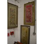 Three Chinese embroidered pictures depicting numerous figures in various scenes.