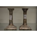 A pair of silver corinthian column candlesticks.