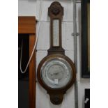 An oak cased aneroid barometer and thermometer.
