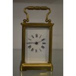 A brass carriage clock with replacement escapement (original escapement included).