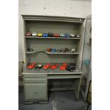 A green painted work unit with shelves.