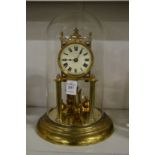 A brass anniversary clock with glass dome.