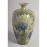 WILLIAM MOORCROFT FLORIAN DESIGN VASE with blue corn flowers on a green ground. Signed: W. Moorcroft