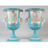 A LARGE PAIR OF CONTINENTAL LIGHT BLUE TWO HANDLED URN SHAPED VASES with heads as handles. 17ins