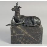 A SMALL BRONZE OF A DEER 5ins long on a marble plinth.