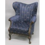 A GEORGE III STYLE MAHOGANY WING ARMCHAIR on claw and ball feet.