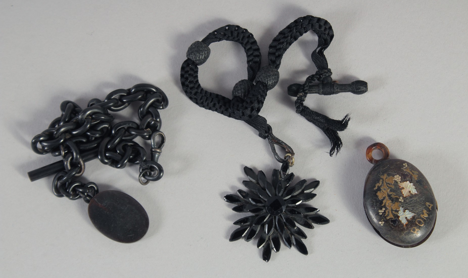 A JET FOB CHAIN, PENDANT AND TORTOISESHELL LOCKET. (3).