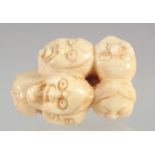 A CARVED BONE FACES NETSUKE.