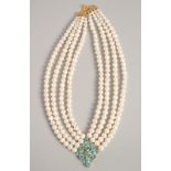 A FOUR STRAND PEARL NECKLACE with blue topaz clasp.