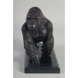 A BRONZE STANDING GORILLA on a marble base.