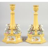 A PAIR OF CONTINENTAL YELLOW GROUND SPHINX CANDLE STICKS. 12ins high.