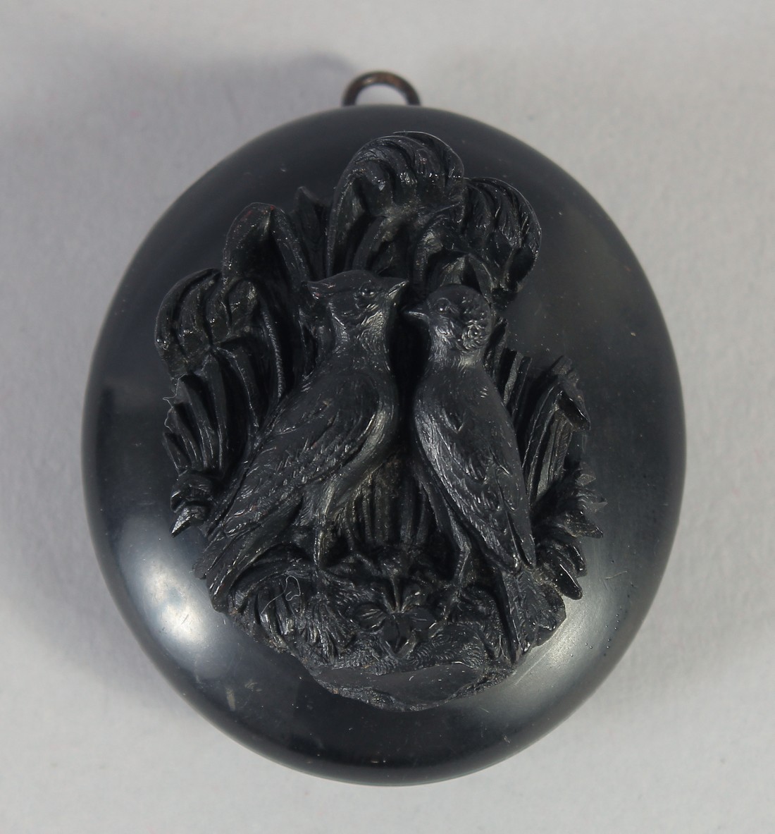 A GOOD VICTORAIN JET OVAL LOCKET carved with two birds. 1.75ins x 1.5ins, 20gms.