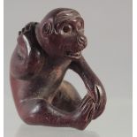 A CARVED WOOD NETSUKE, MONKEY. Signed.