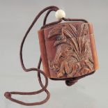 A SMALL CARVED WOOD INRO with rope.