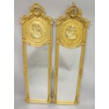A PAIR OF GILTWOOD NARROW MIRRORS the upper panel with the bust of a lady. 5ft 10ins x 1ft 9ins.