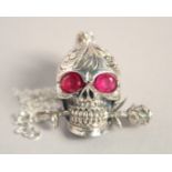 A SILVER SKULL holding a rose, on a chain.