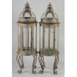 A PAIR OF CIRCULAR LANTERNS on curving legs. 2ft 8ins high.