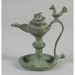 A 13TH CENTURY PERSIAN SELJUK BRONZE OIL LAMP, the handle with a bird finial, 12.5cm high.