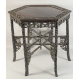 A CHINESE HEXAGONAL HARDWOOD TABLE, with carved and pierced skirt and detachable folding foliate