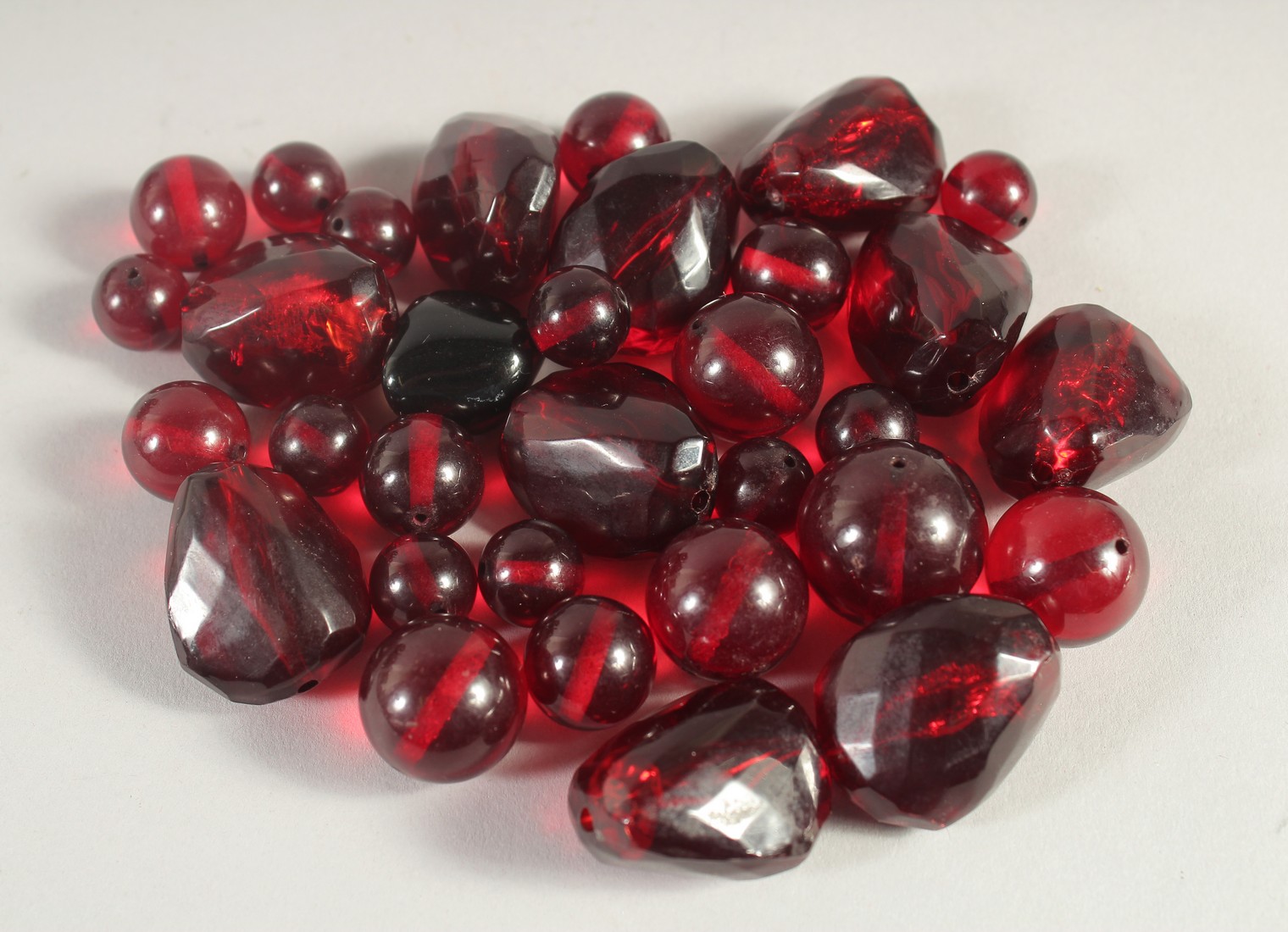 A COLLECTION OF RUBY-COLOUR BEADS, various sizes, (qty).