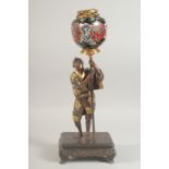 A FINE JAPANESE MEIJI PERIOD BRONZE OKIMONO holding a cloisonne urn aloft, the figure with gilt