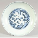 A CHINESE BLUE AND WHITE DRAGON DISH, with central incised white dragon, the base with six-character