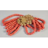 A GOLD ISLAMIC FIVE ROW CORAL NECKLACE with long gold filigree clasp.