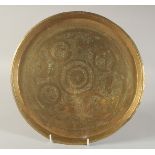 AN ENGRAVED AND CHASED BRASS DISH, with animals and flora, 29.5cm diameter.